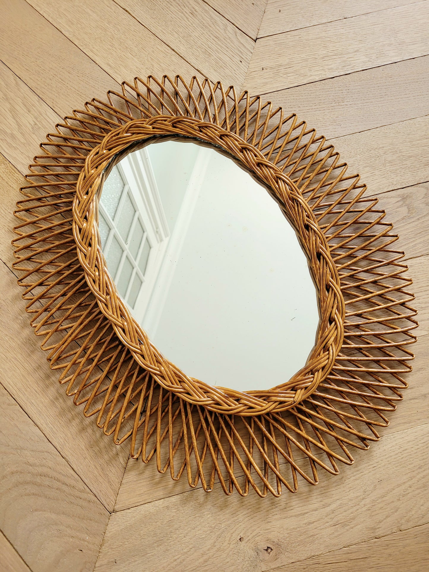 full view of an oval wall mirror in wicker texture