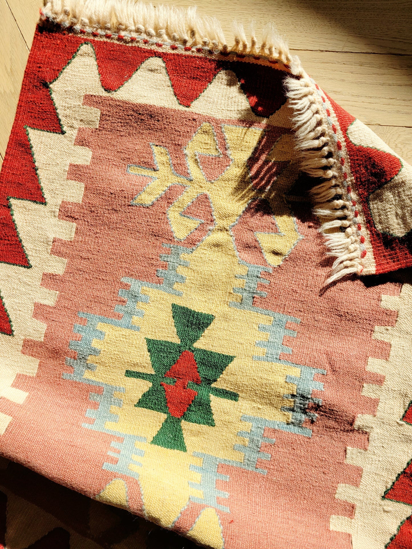 detail of a bright and colourful vintage kilim rug with geometrical pattern
