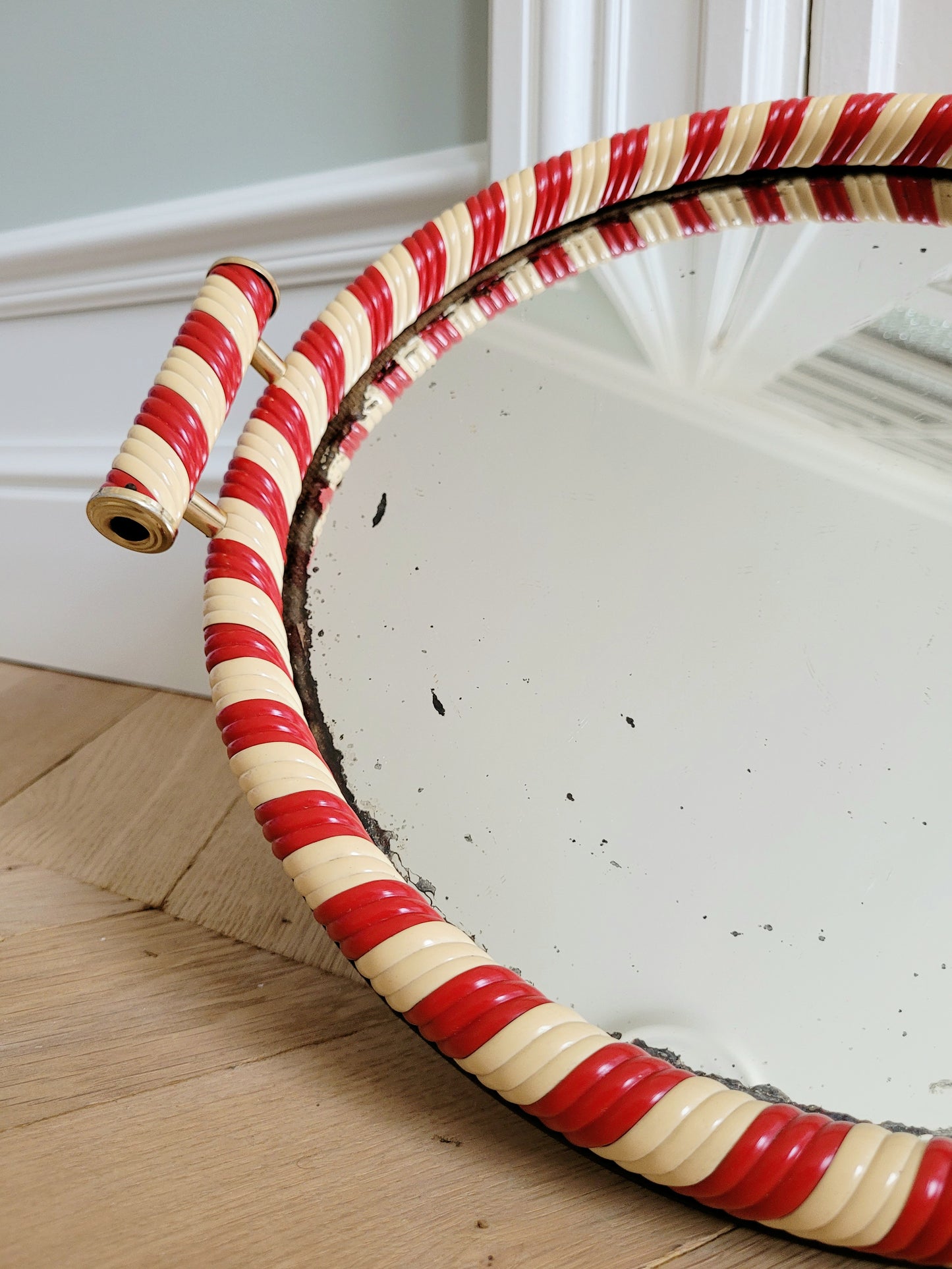 detail of a vintage mirror tray featuring a candy cane stripe design