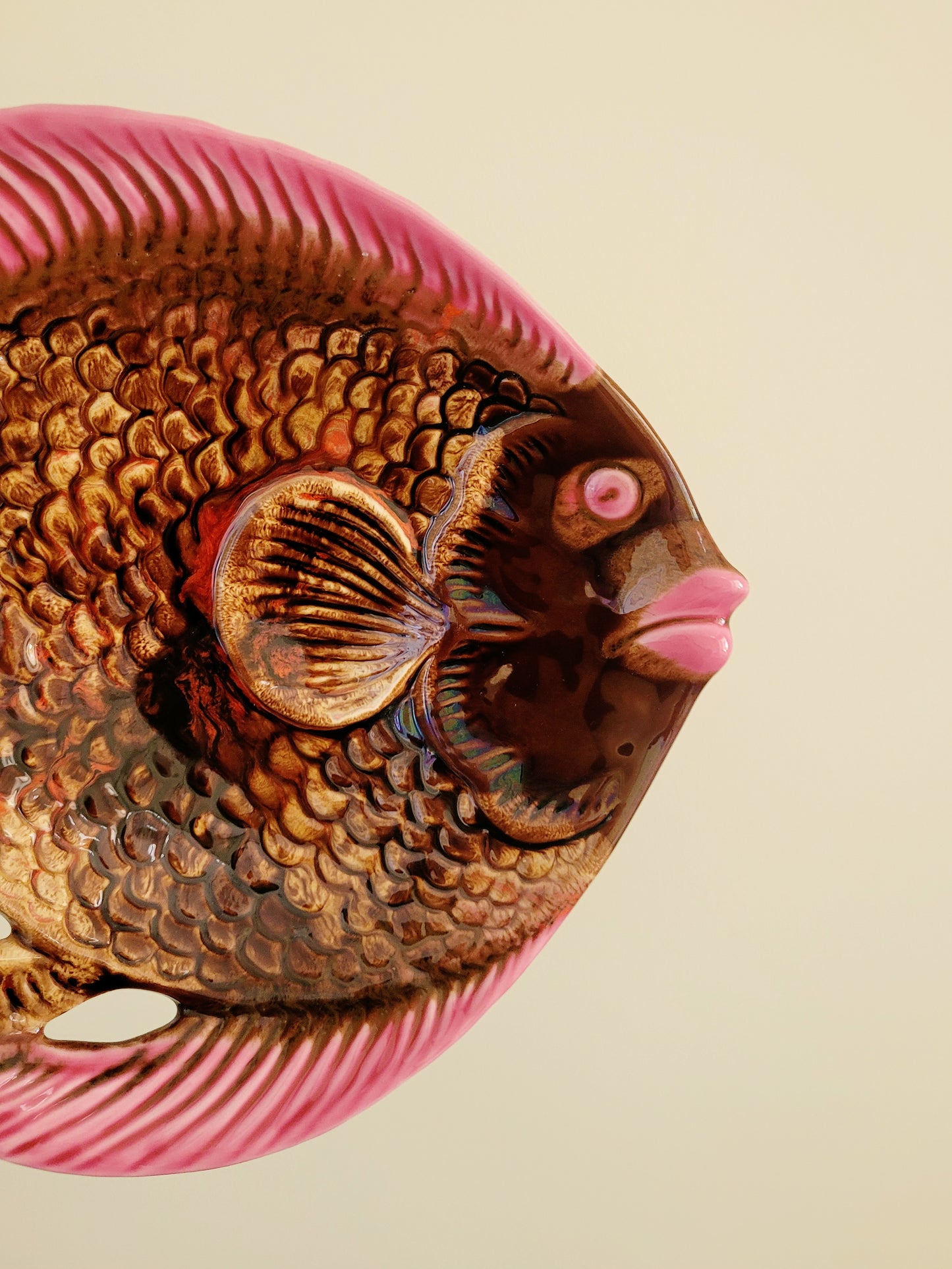 detail of a quirky ceramic serving bowl in fish shape in purple pink and brown