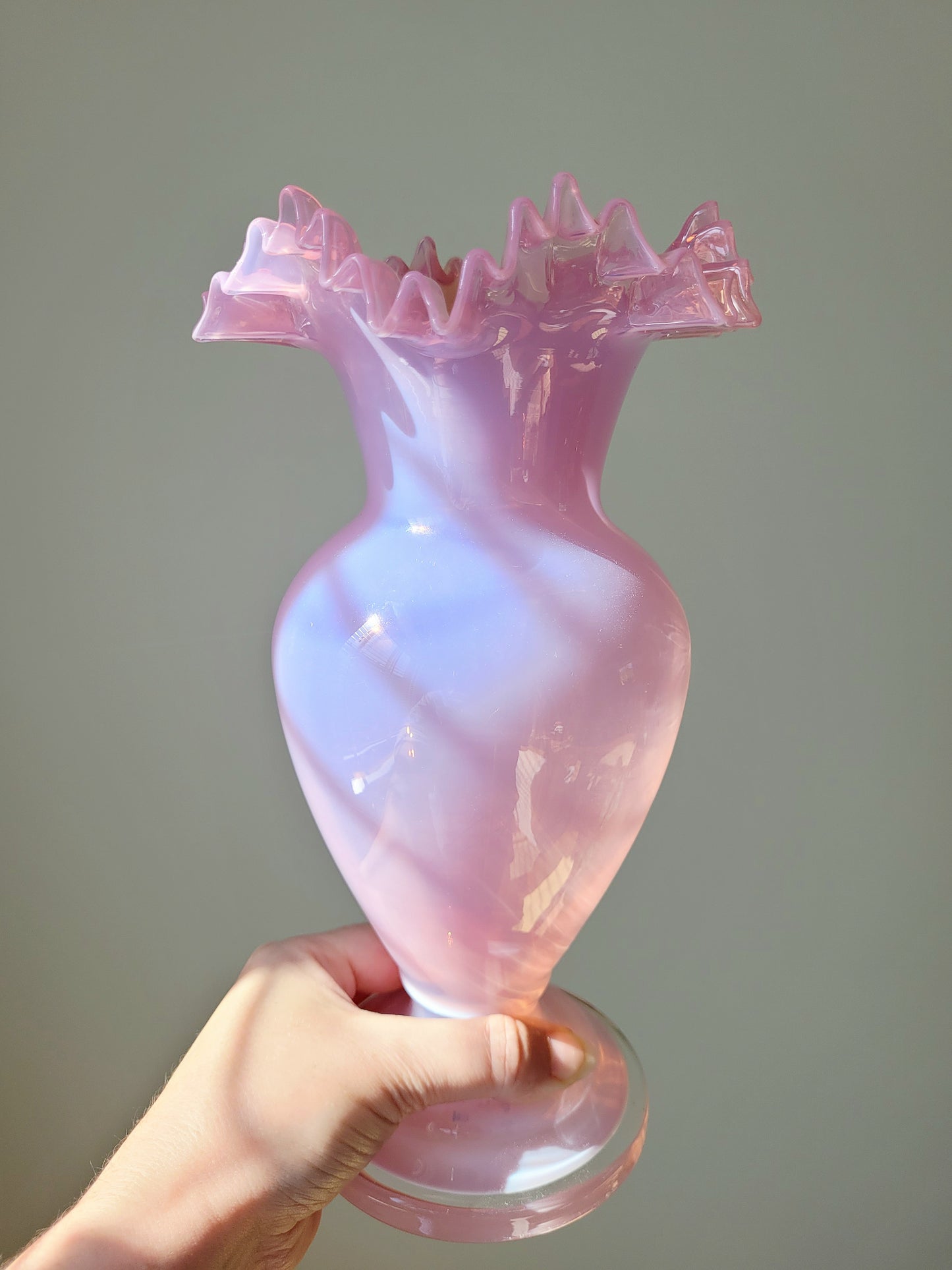 front view of a pink opaline glass vase handheld