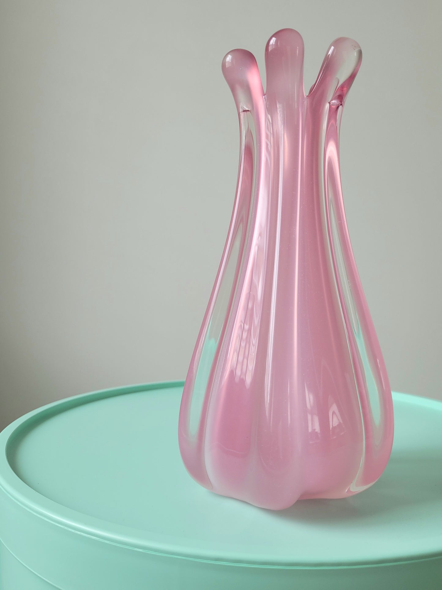 front view of a unique vintage Murano pink hue alabaster vase on a mint green side table