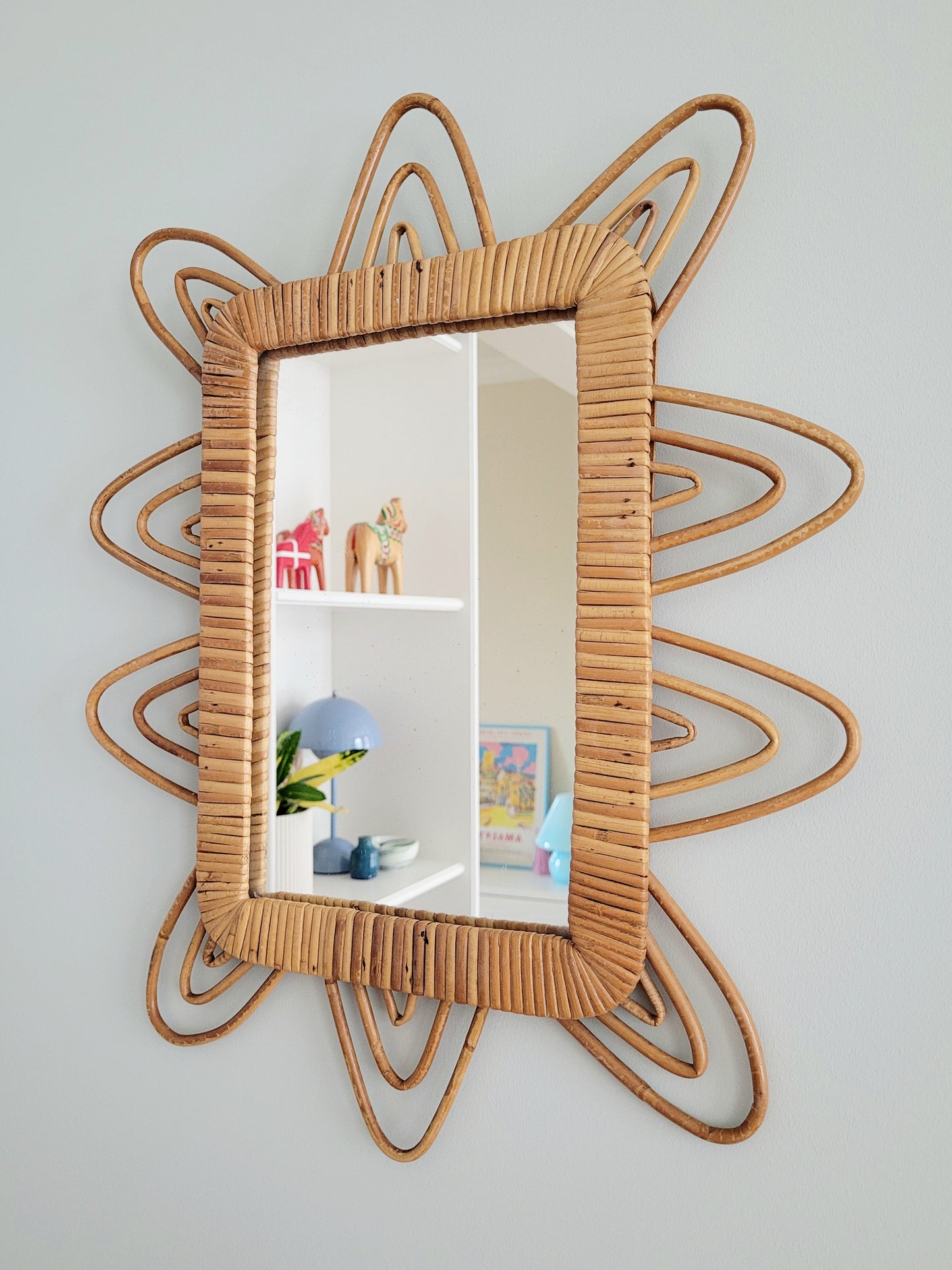 side view of a playful vintage wall mirror with rattan frame