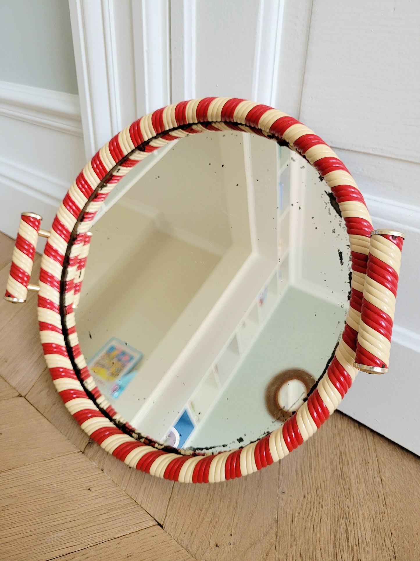 side view of a vintage mirror tray featuring a candy cane stripe design