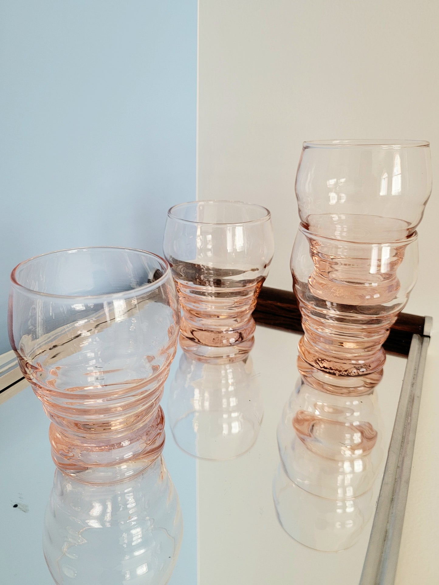 side view of coral art deco drinking glasses on a mirror tray