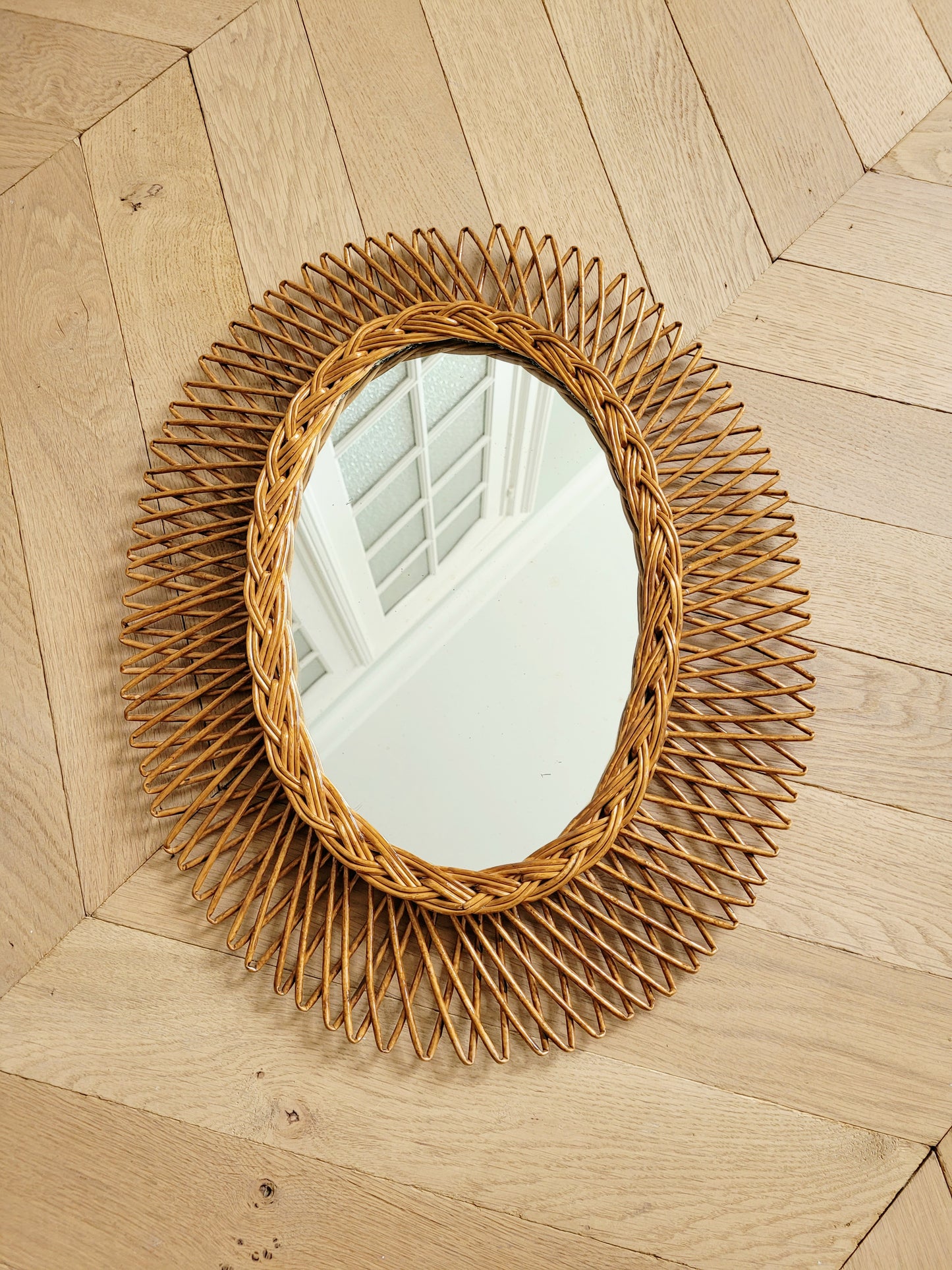 full view of an oval wall mirror in wicker texture