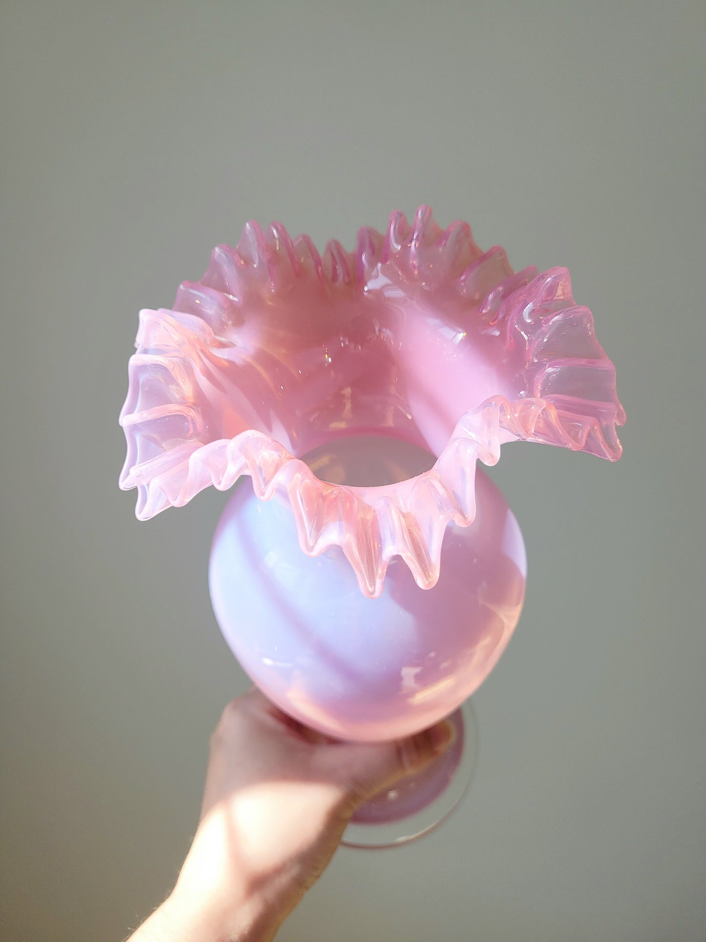 top view of a pink opaline glass vase handheld