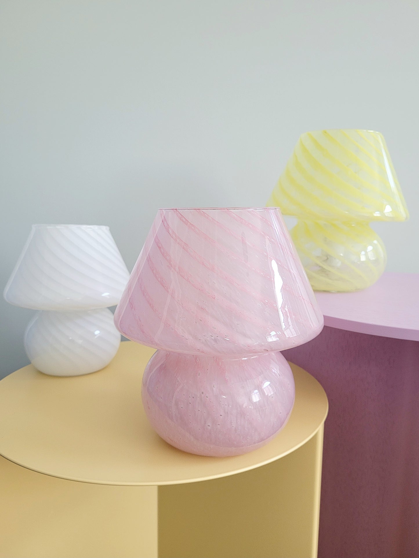 front view of a trio of small colourful vintage Murano mushroom table lamps with yellow pink and white swirls