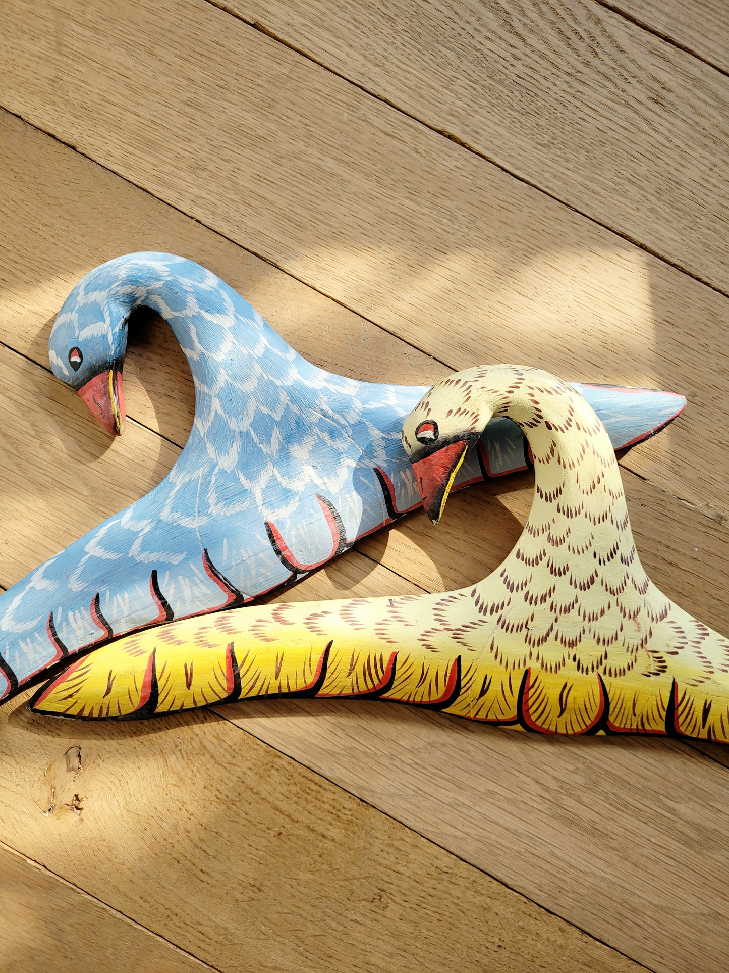 detail of two playful wooden hangers in a bird shape