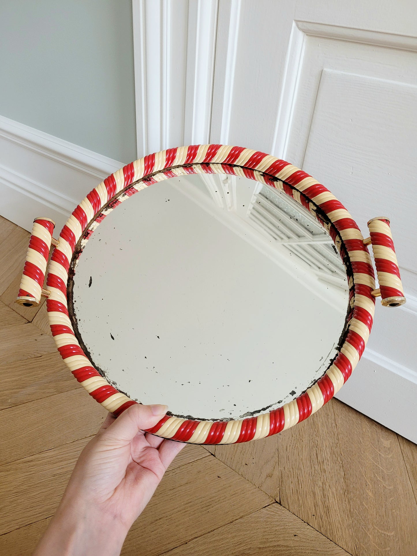 full view of a vintage mirror tray featuring a candy cane stripe design handheld