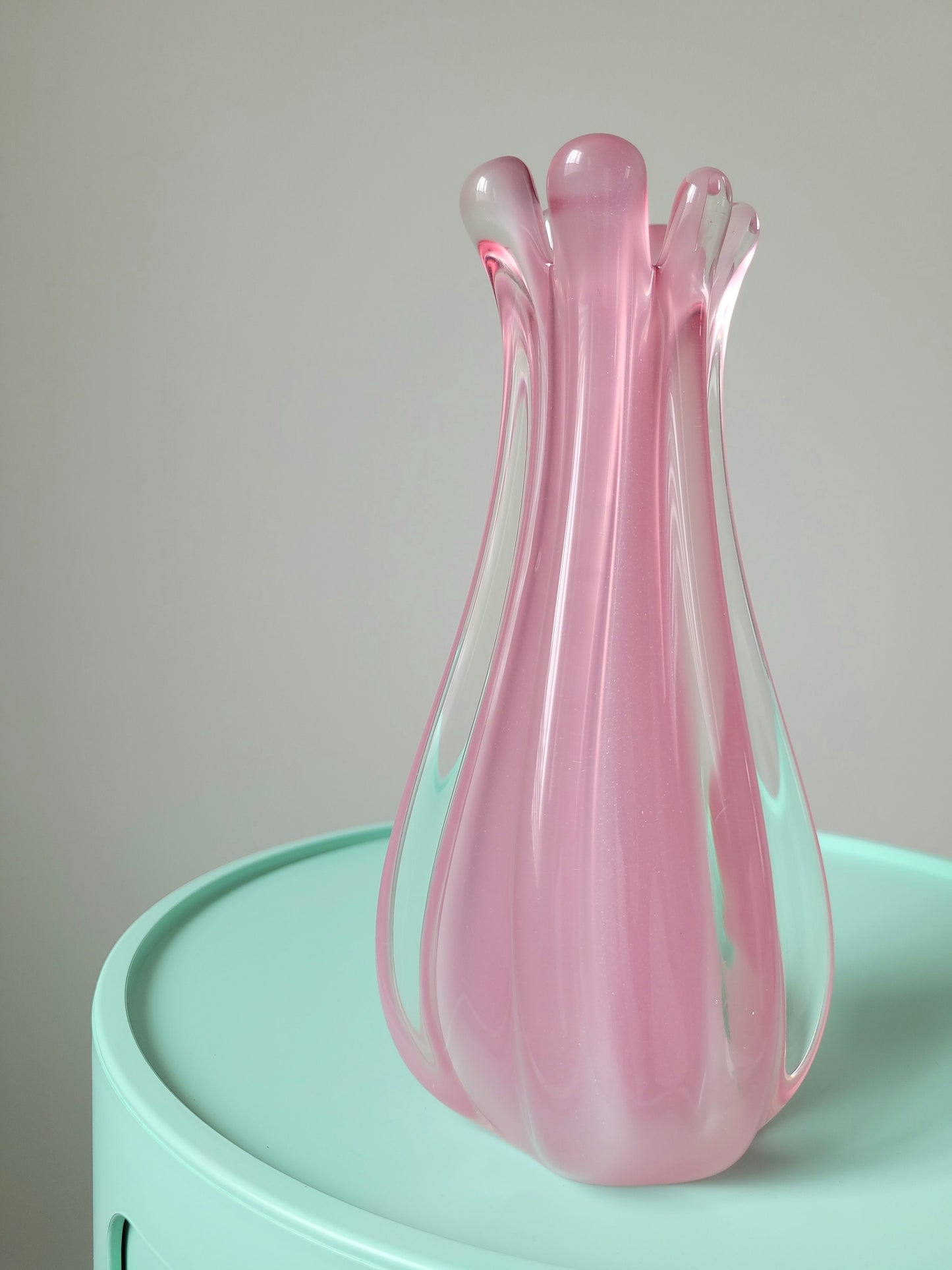 front view of a unique vintage Murano pink hue alabaster vase on a mint green side table