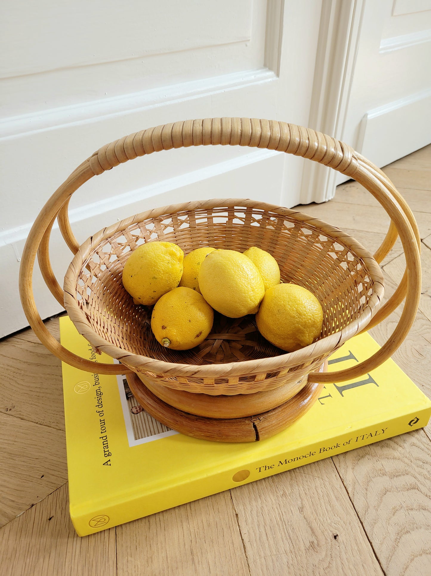 top view of a wicker and rattan fruit basket filled with lemons