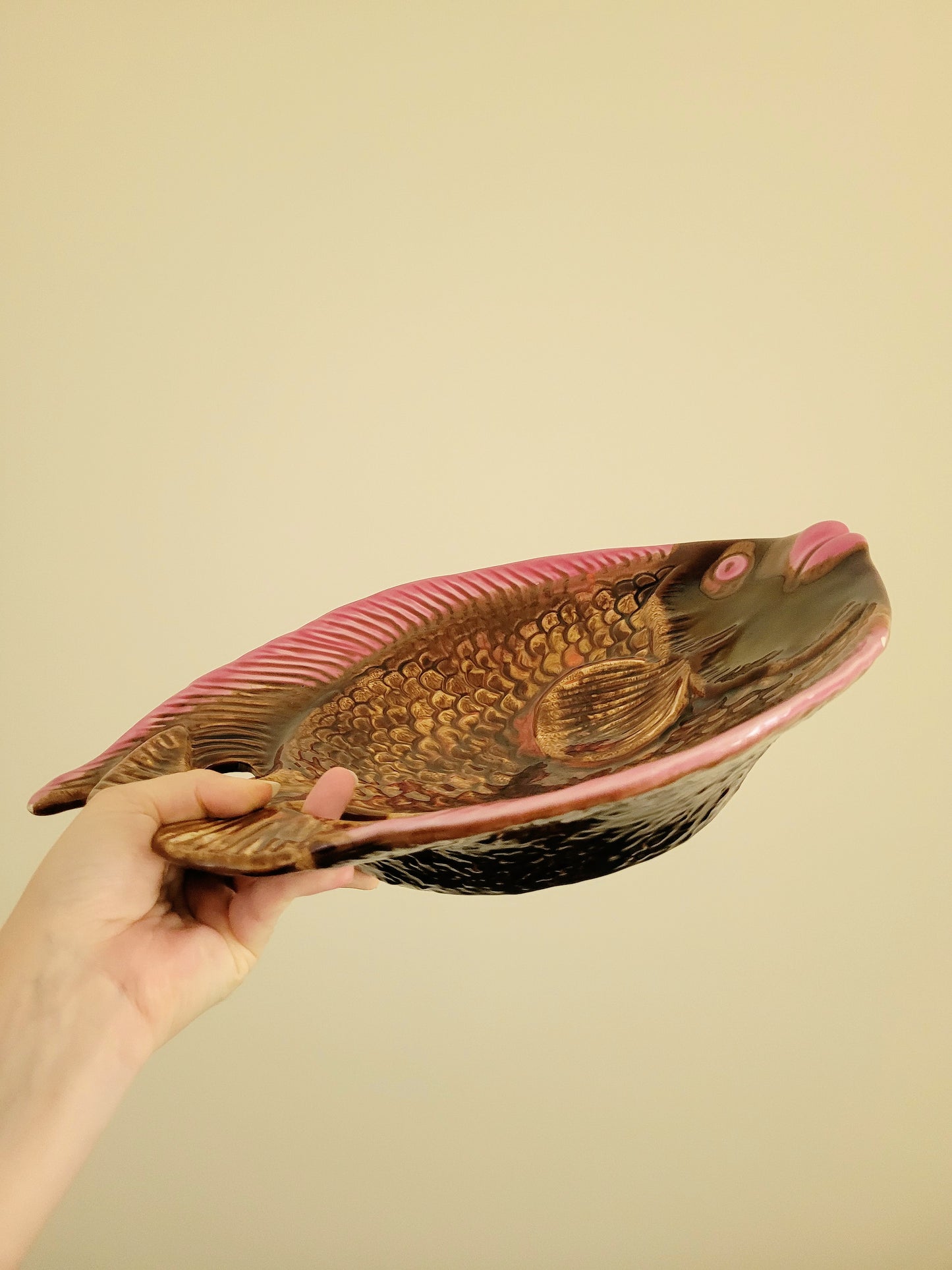 side view of a quirky ceramic serving bowl in fish shape in purple pink and brown