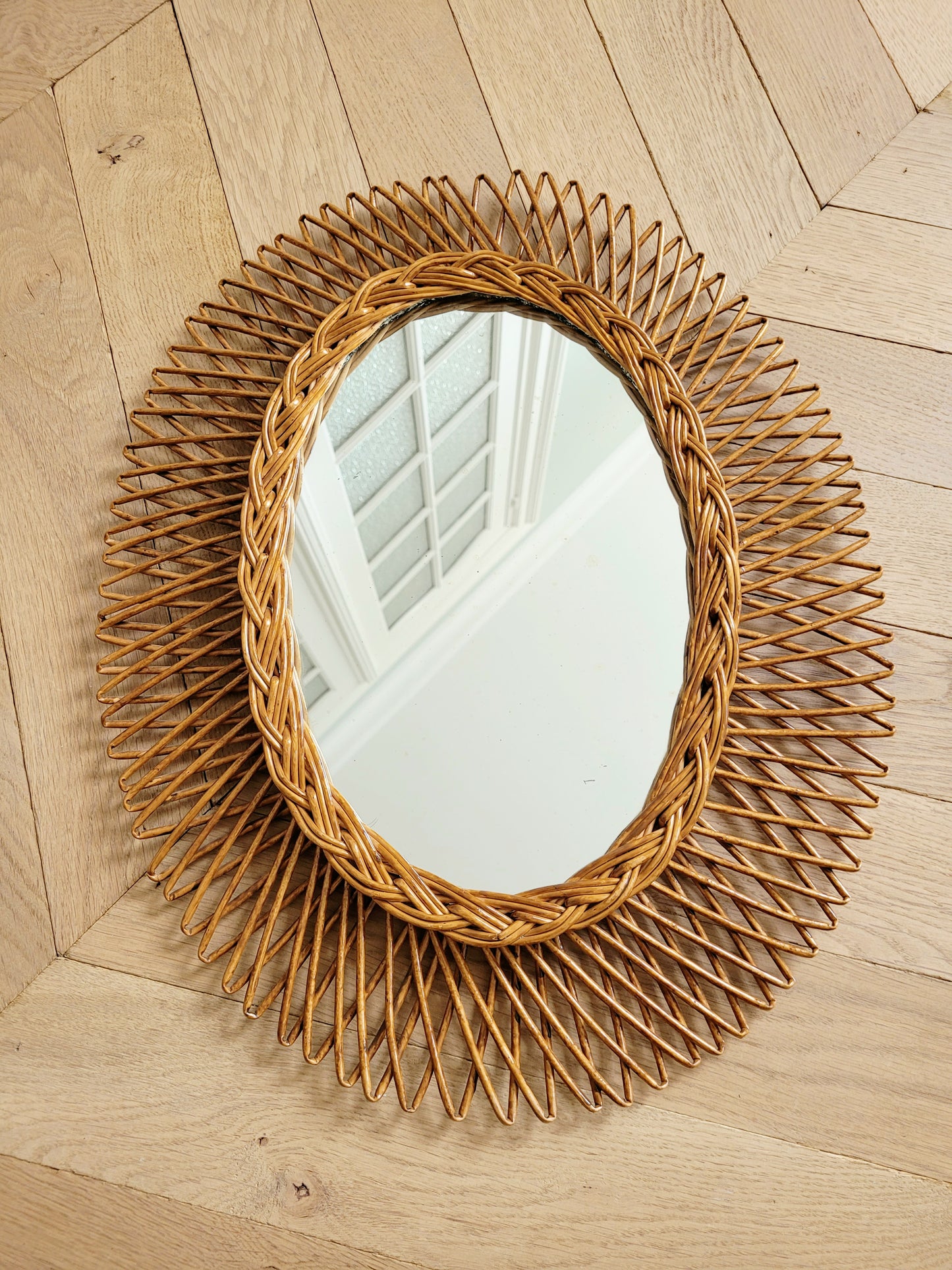 full view of an oval wall mirror in wicker texture