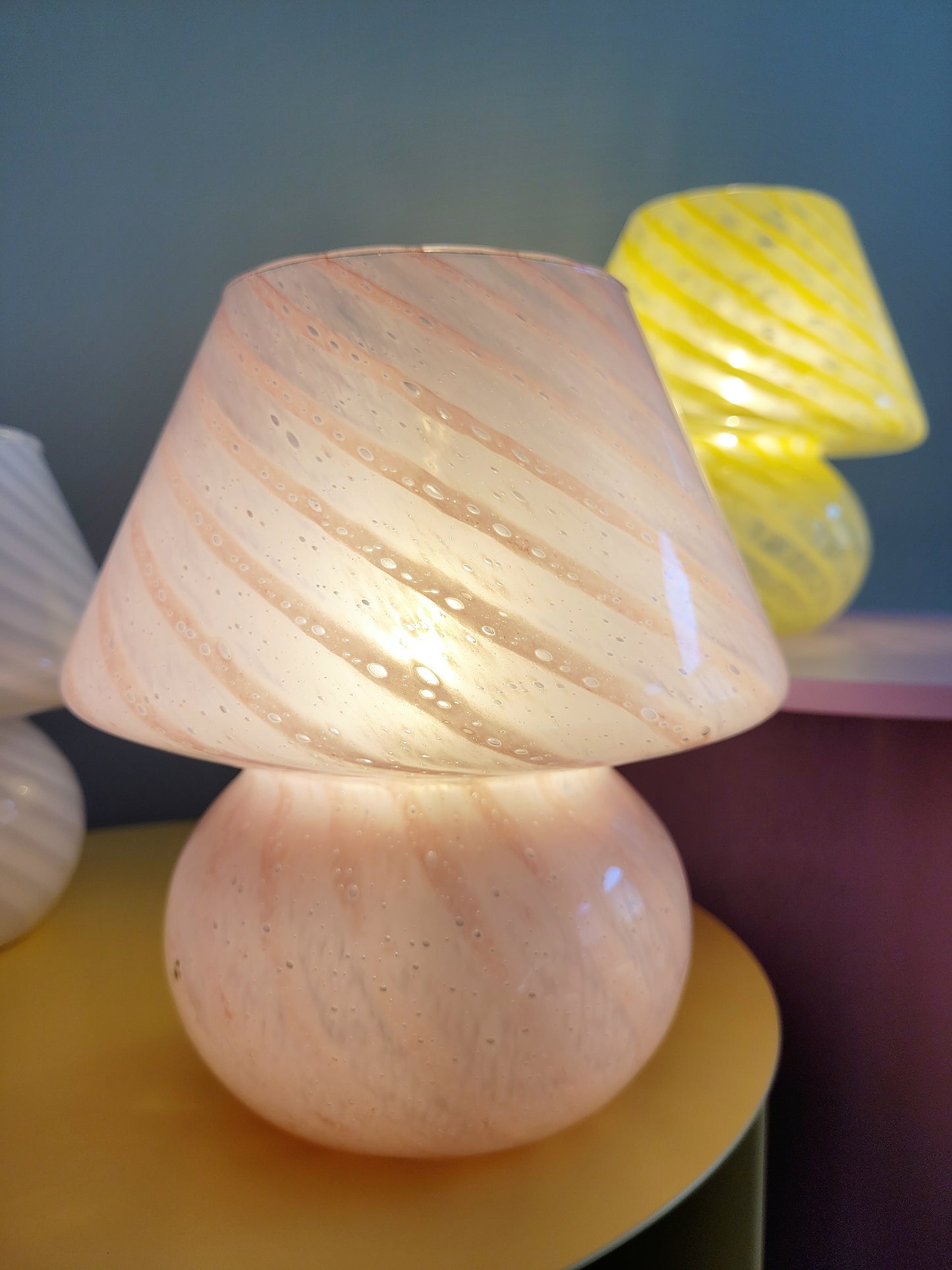 front view of a trio of small colourful vintage Murano mushroom table lamps with yellow pink and white swirls