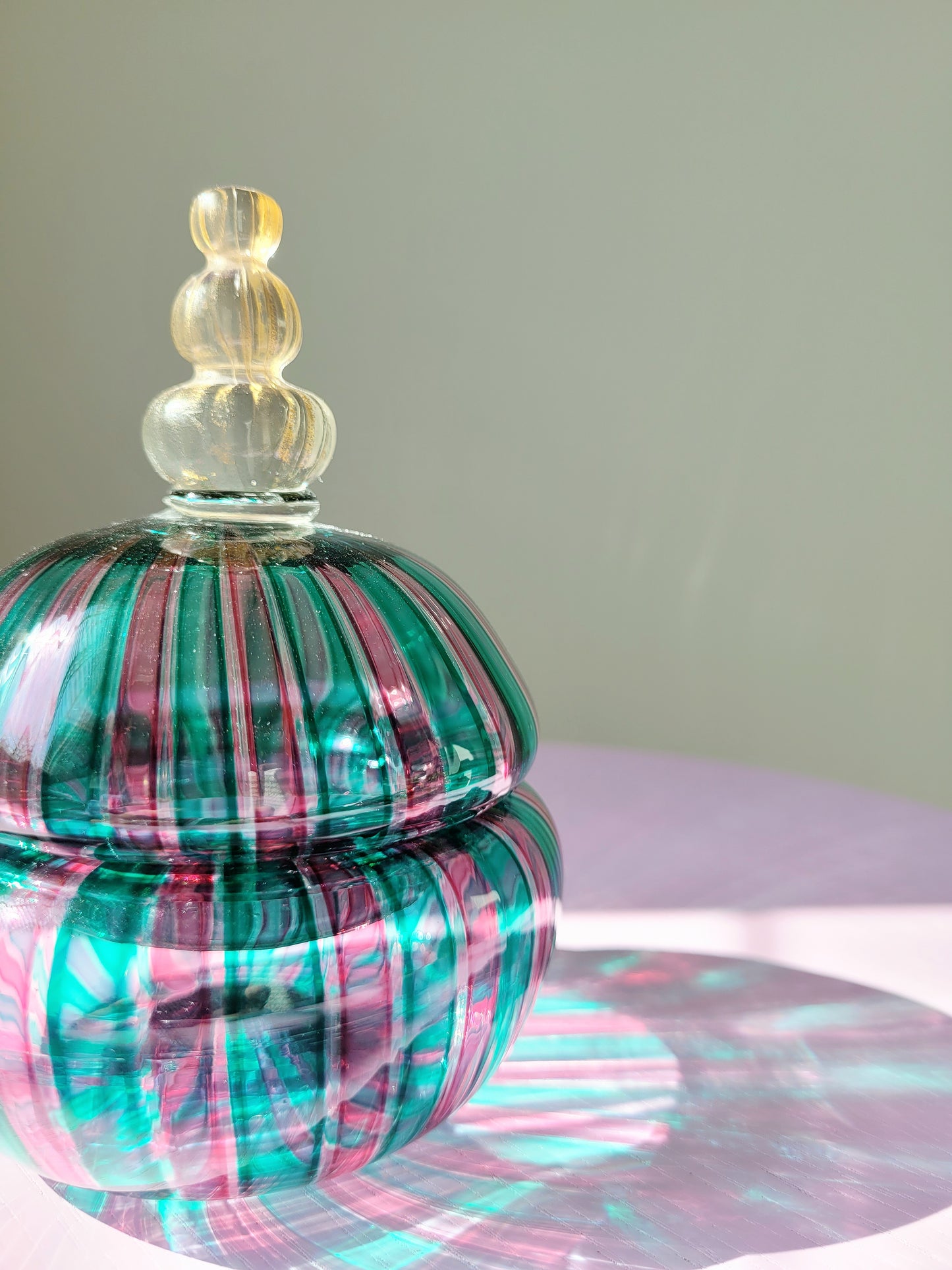 front view of a handcrafted vintage striped Murano bonbonniere in green pink and gold