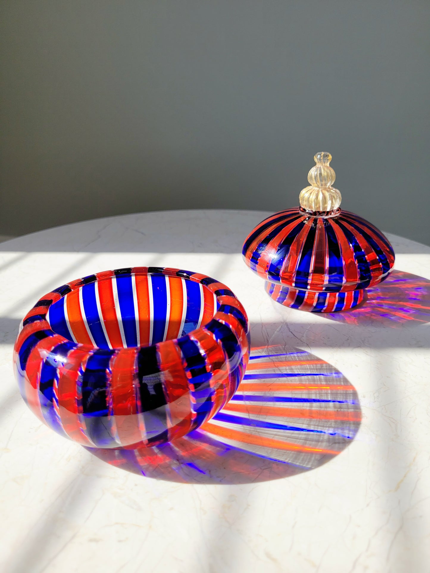 detail of a handcrafted vintage striped Murano bonbonniere in red blue and gold