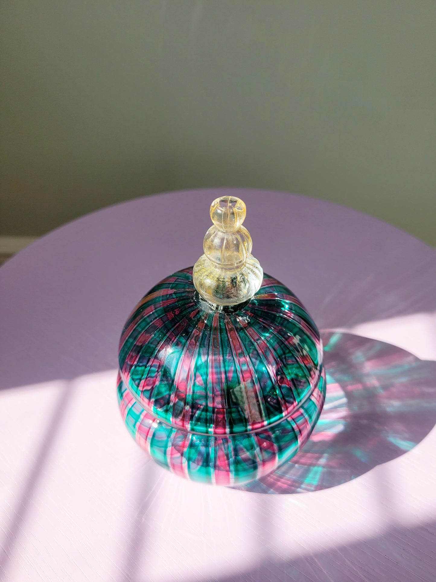 top view of a handcrafted vintage striped Murano bonbonniere in green pink and gold