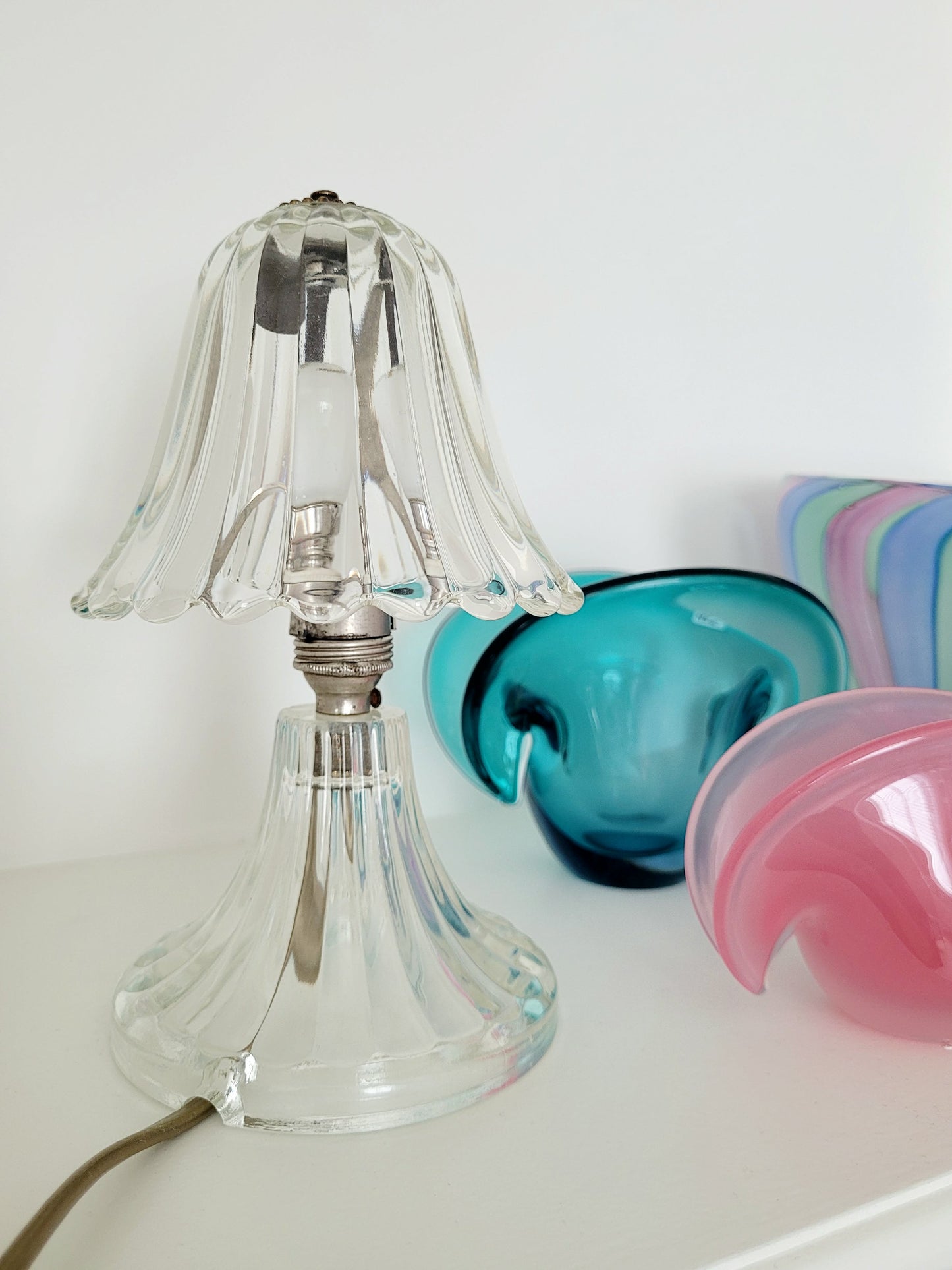 front view of a clear Murano glass table lamp with scalloped shade