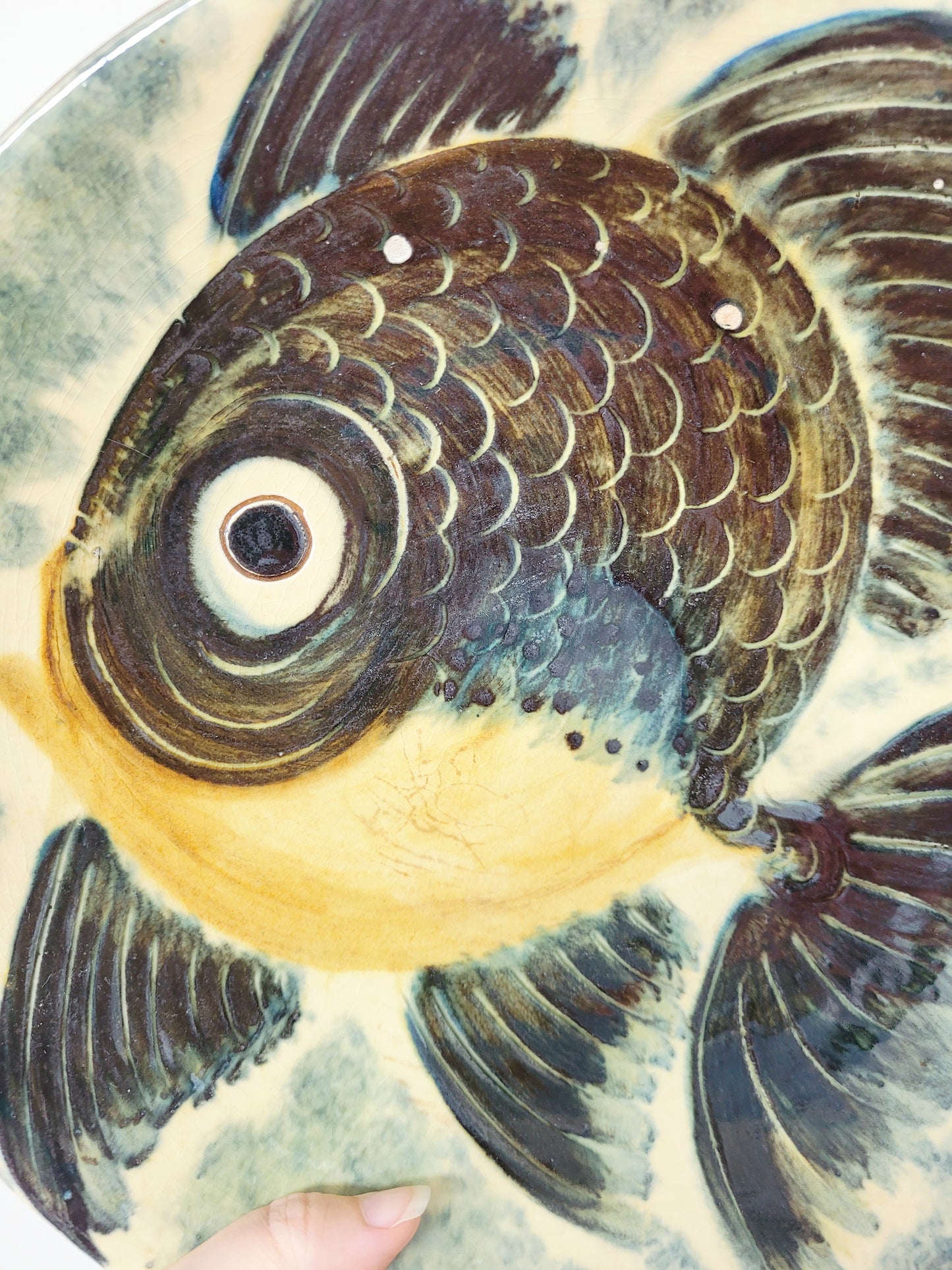 detail of a spanish Puigdemont fish wall plate in greens and yellow