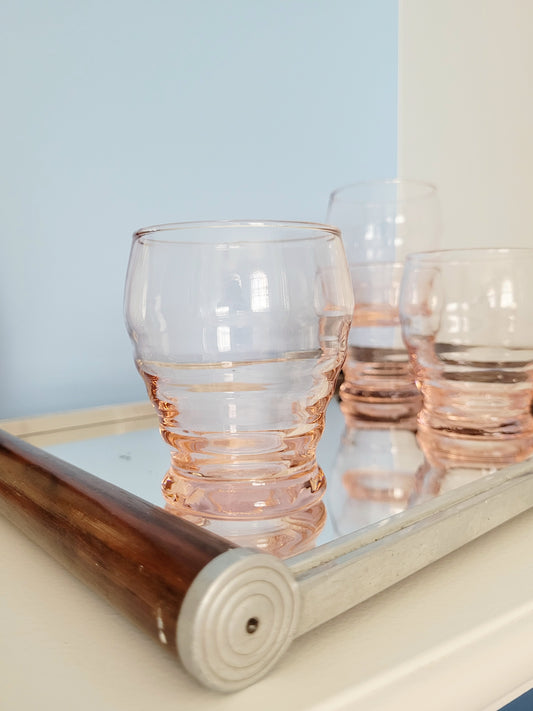 detail of a coral art deco drinking glass on a mirror tray