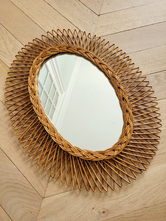 full view of an oval wall mirror in wicker texture