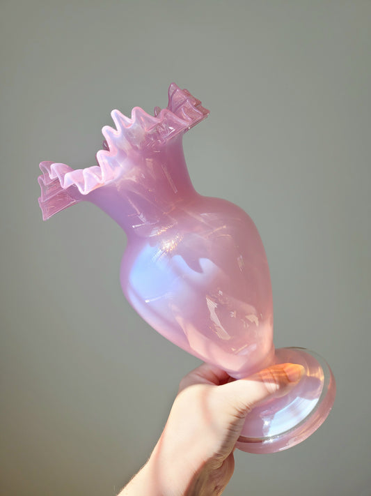 front view of a tilted pink opaline glass vase handheld
