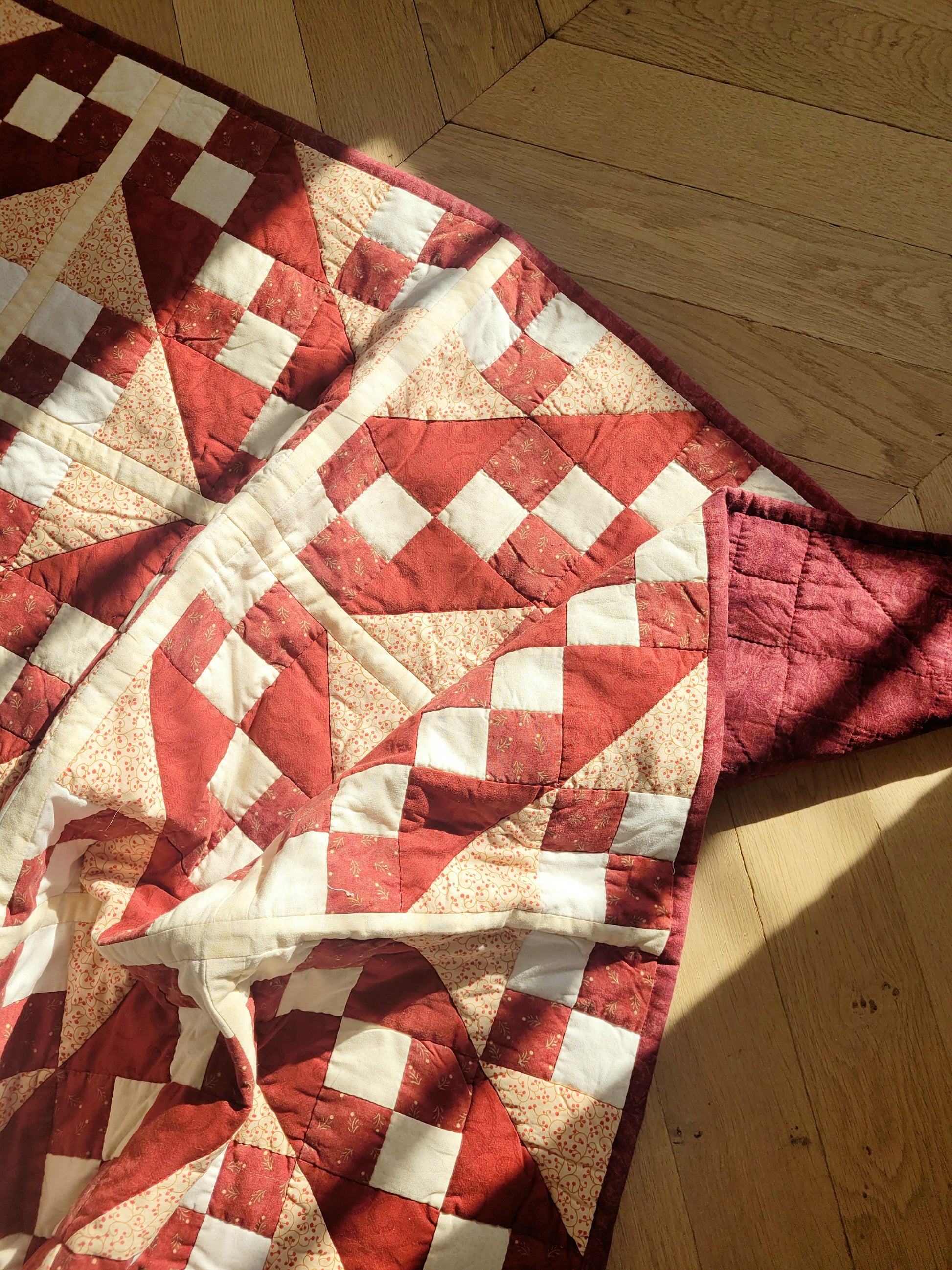 top view of a handmade red and beige patchwork quilt