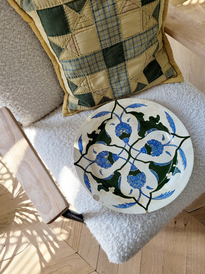 top view of a vintage Italian (wall) plate with blue and green floral motif, made by Fontebasso Treviso, Italy on a white chair