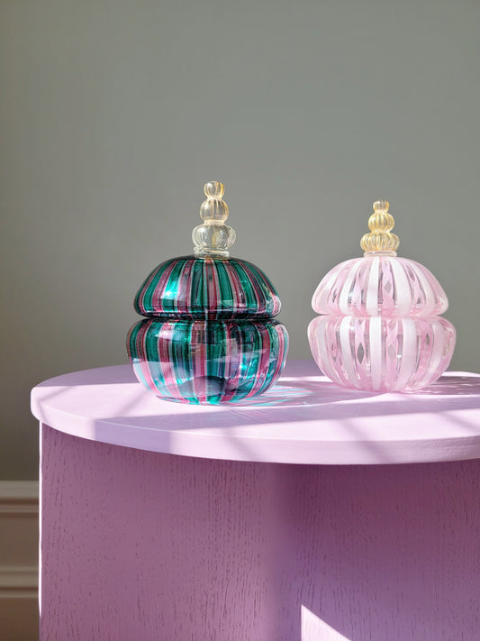 full view of two handcrafted vintage striped Murano bonbonnieres on a purple side table