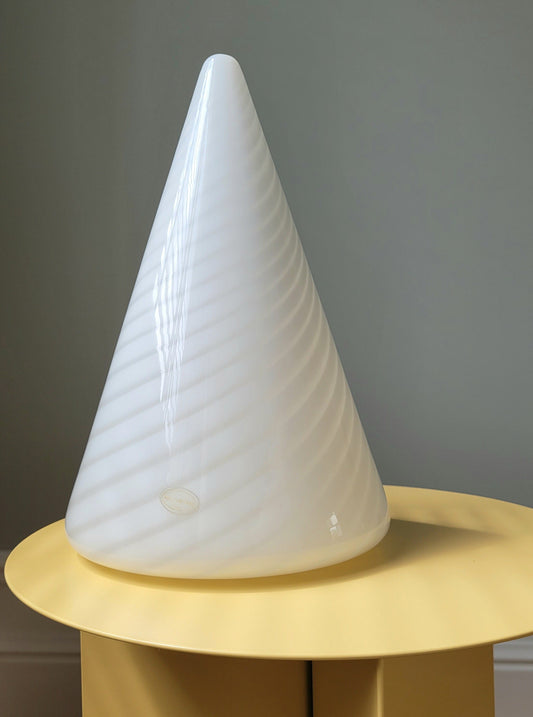 front view of a vintage Murano cone lamp with white and translucent swirl on a yellow side table