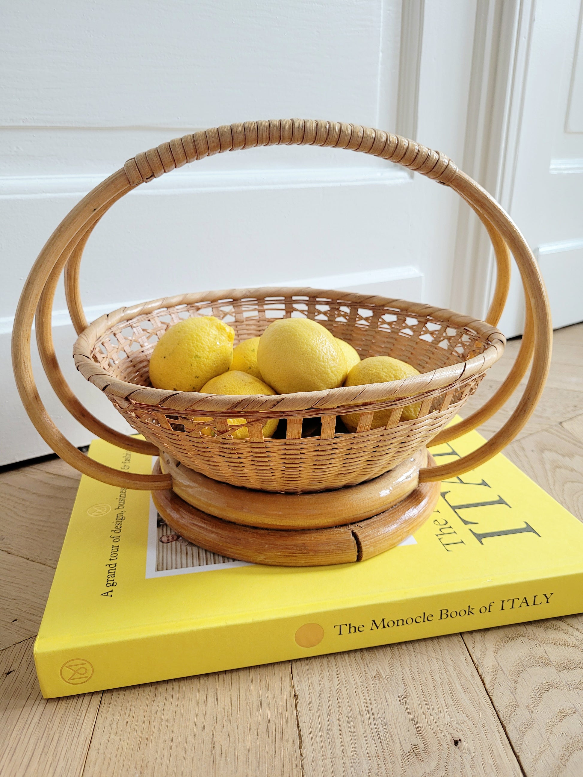 full view of a wicker and rattan fruit basket filled with lemons