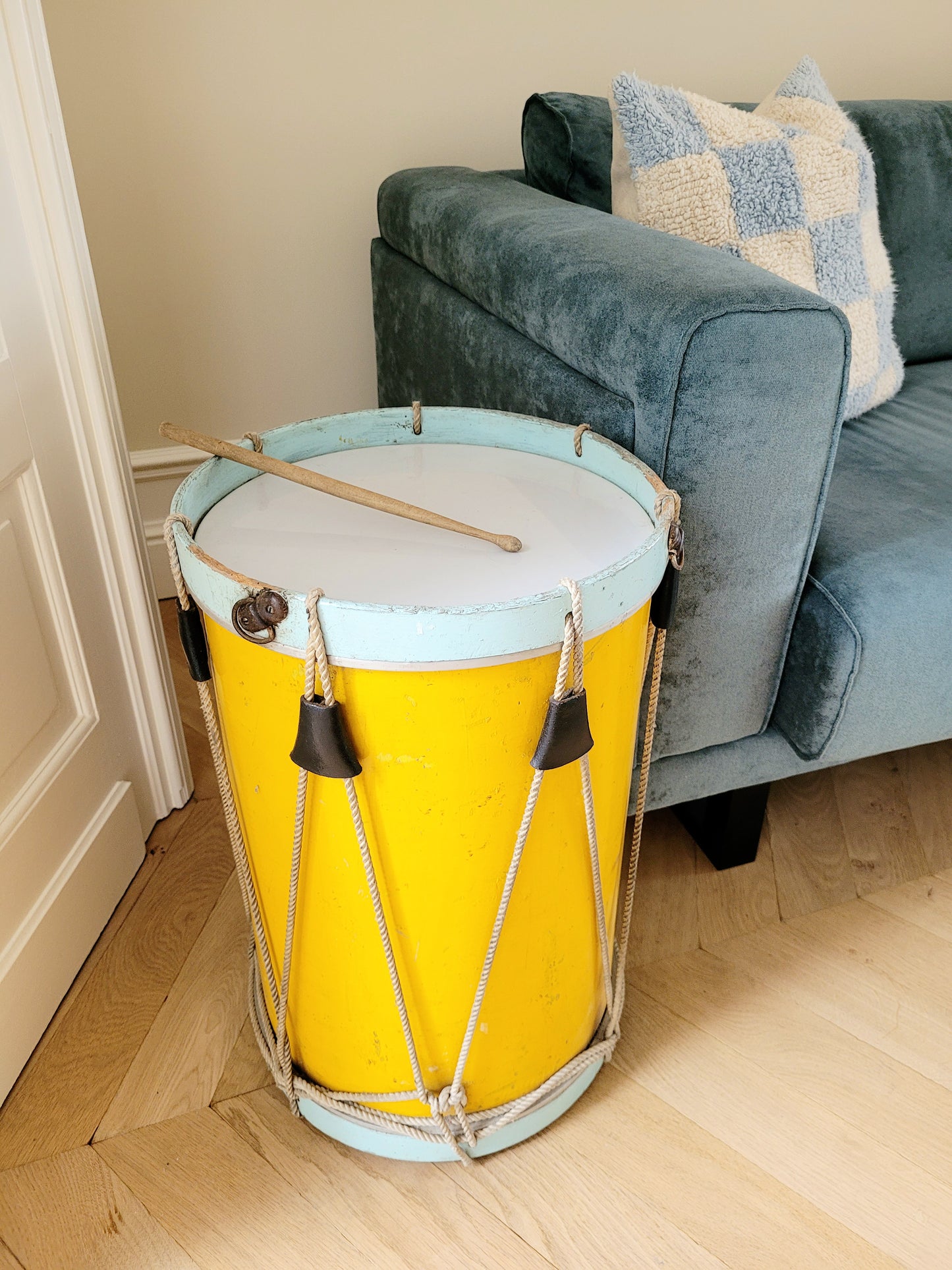 side view of a colourful rope tension drum in vibrant colours in use as a side table