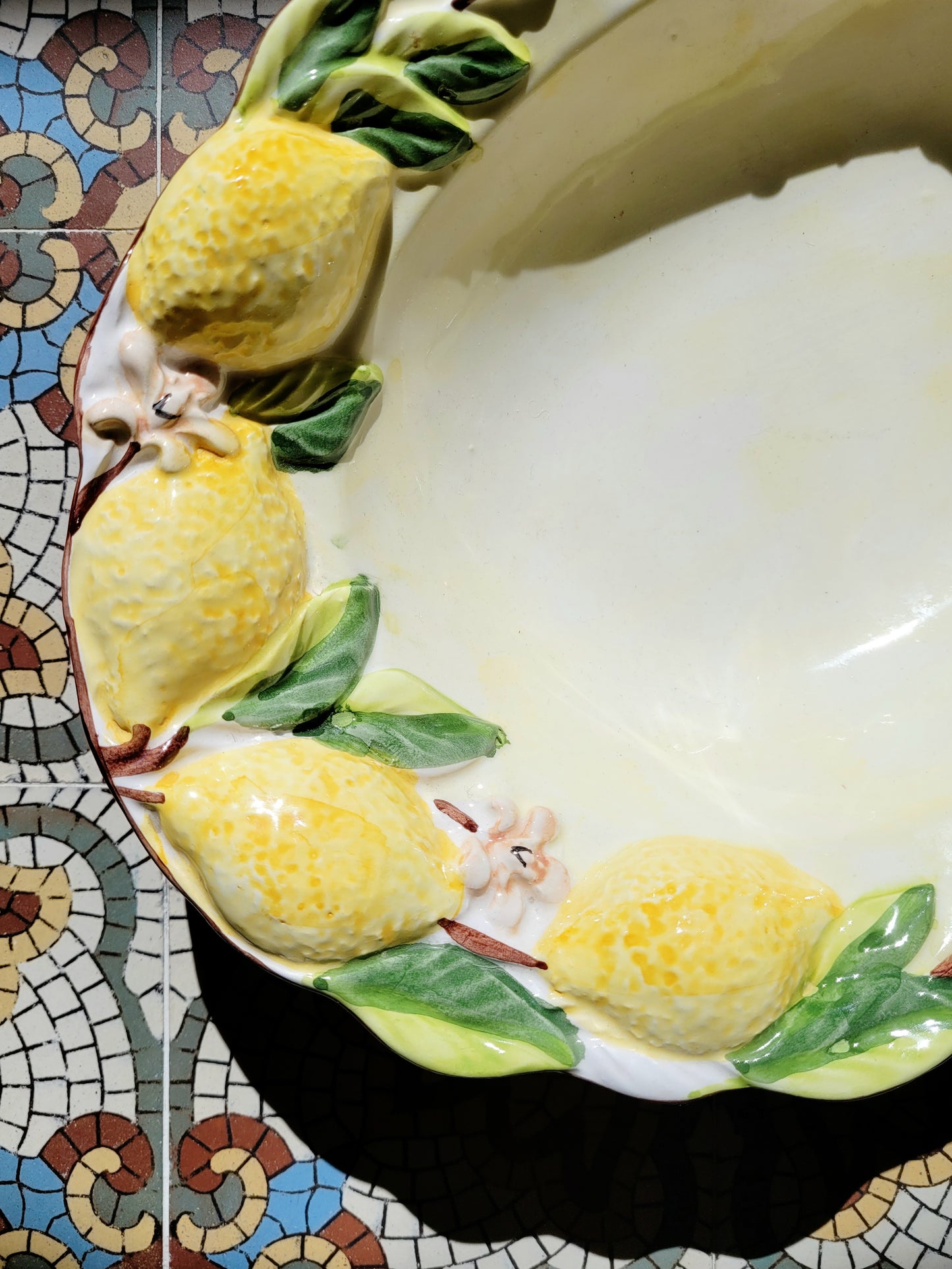 detail of a deep ceramic oval dish with lemons in relief