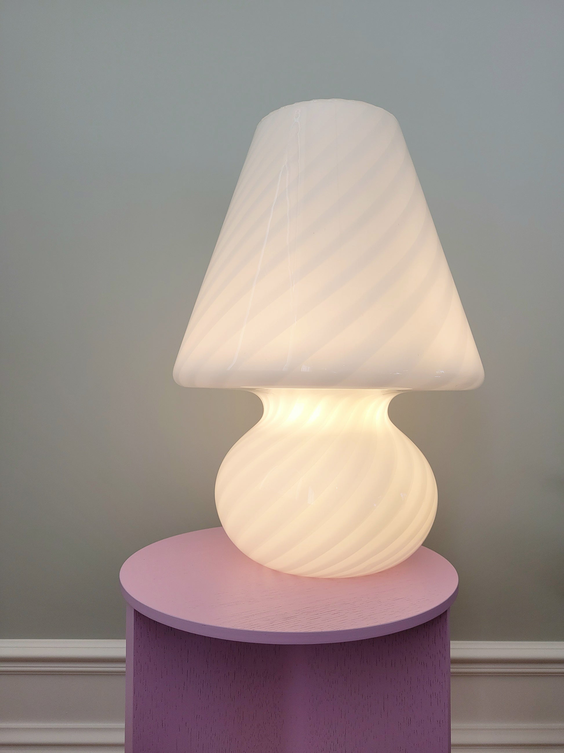 front view of an extra large vintage Murano white swirl mushroom lamp illuminated