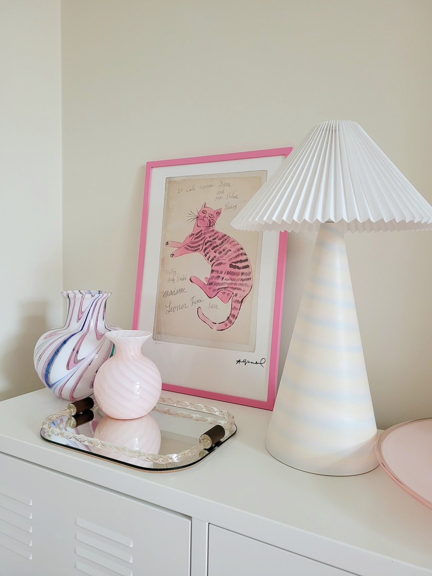 side view of the lithograph cat Sam by Andy Warholl in a pink frame