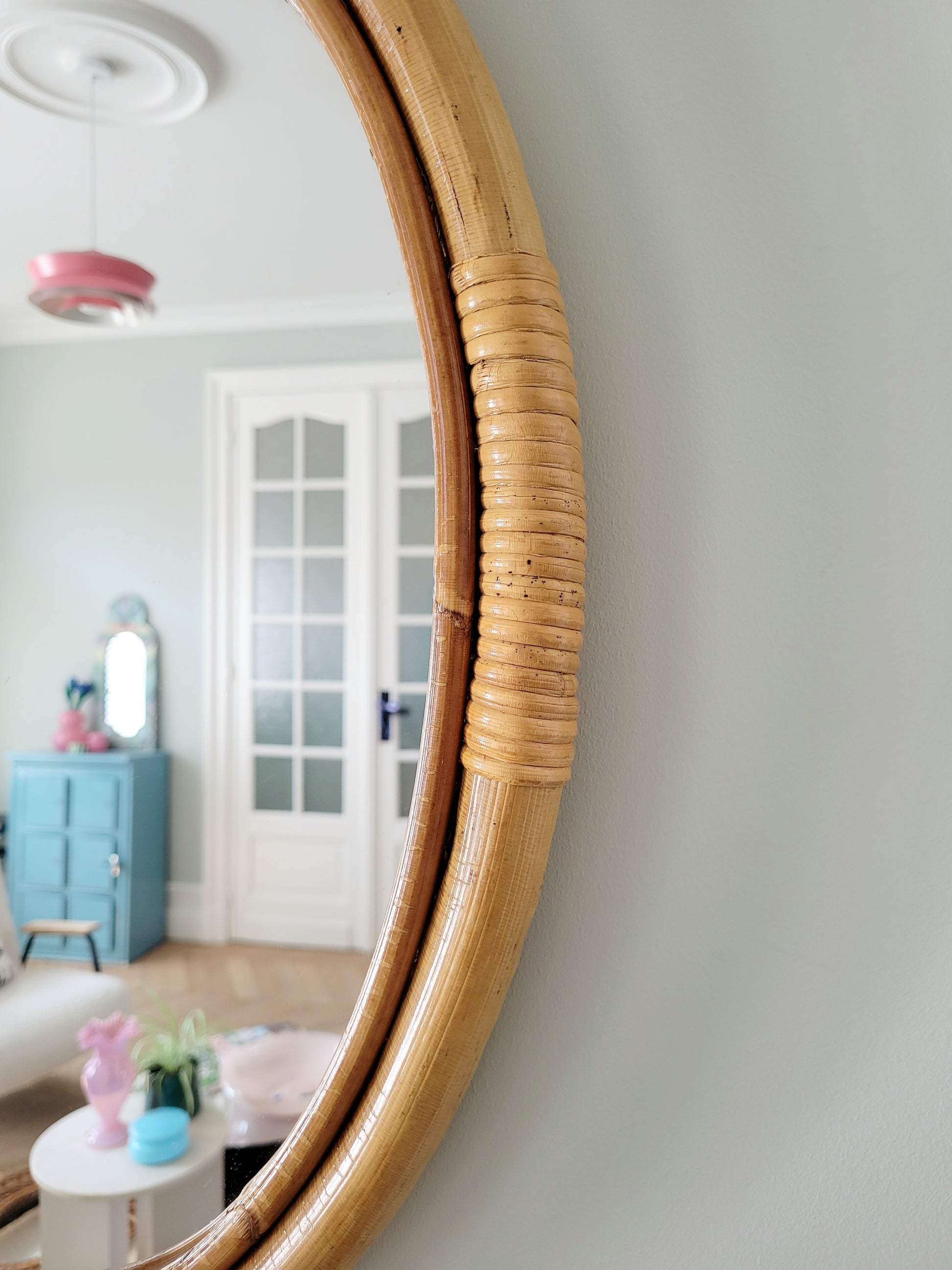 detail of an oval wall mirror in natural bamboo