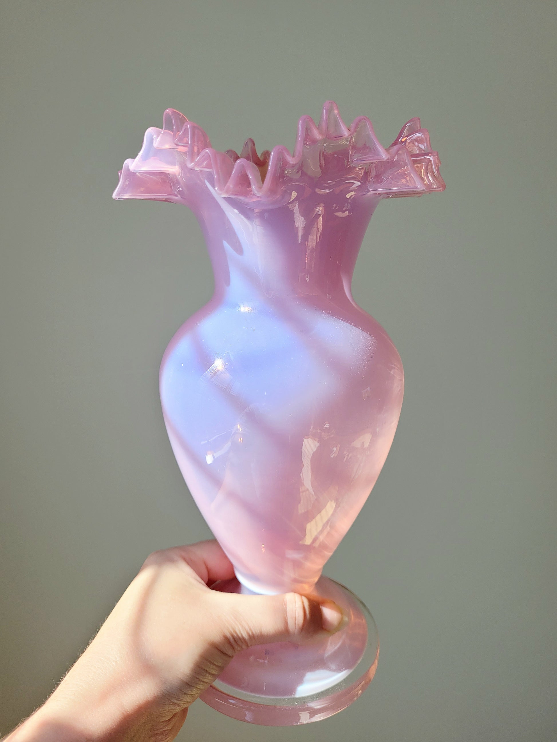front view of a pink opaline glass vase handheld