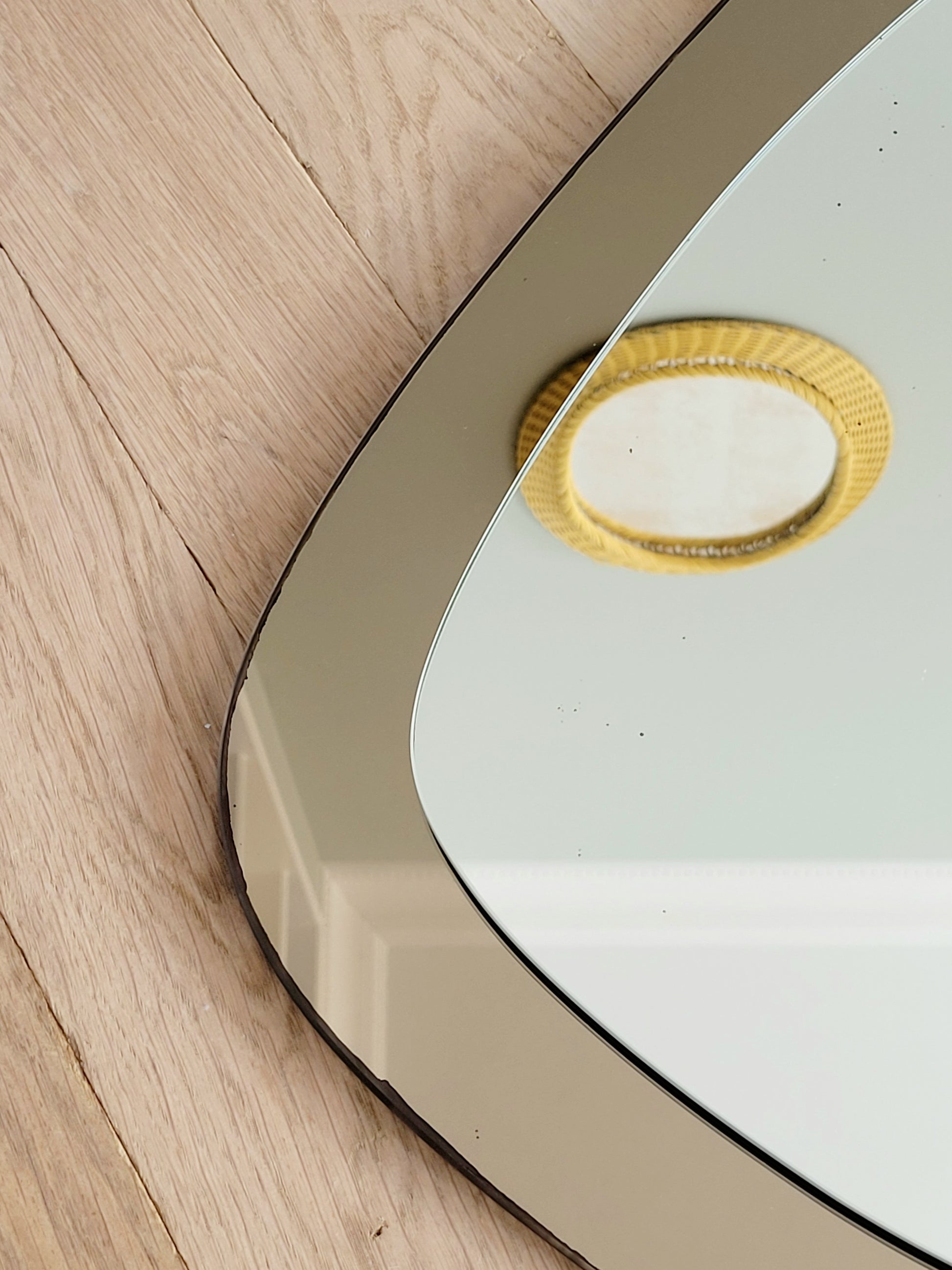 detail of a vintage two-tone Italian wall mirror with smoked glass