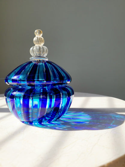 front view of a handcrafted vintage striped Murano bonbonniere in blue and gold