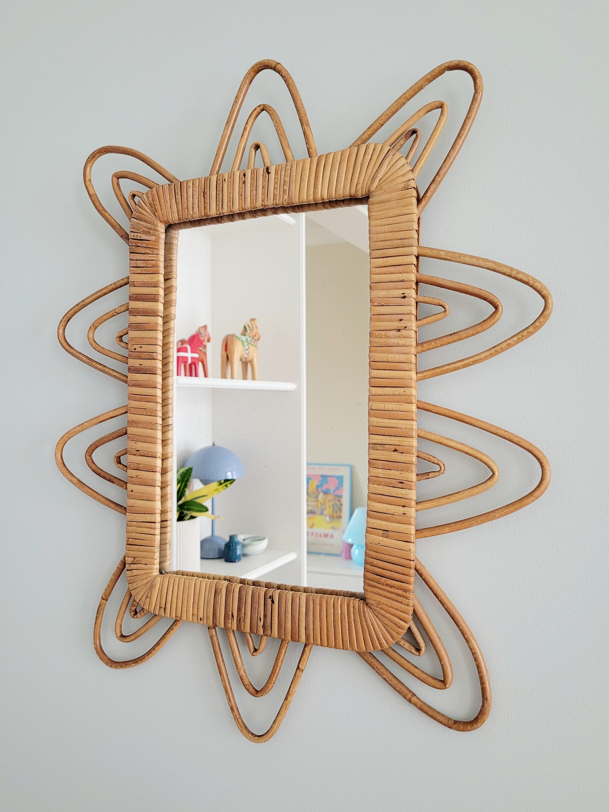 side view of a playful vintage wall mirror with rattan frame