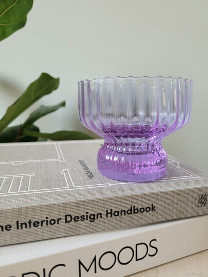 detail of a purple Italian glass and cup on a stack of interior books
