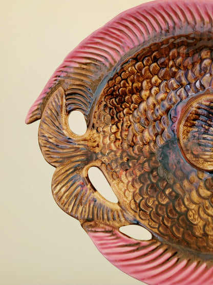 detail of a quirky ceramic serving bowl in fish shape in purple pink and brown