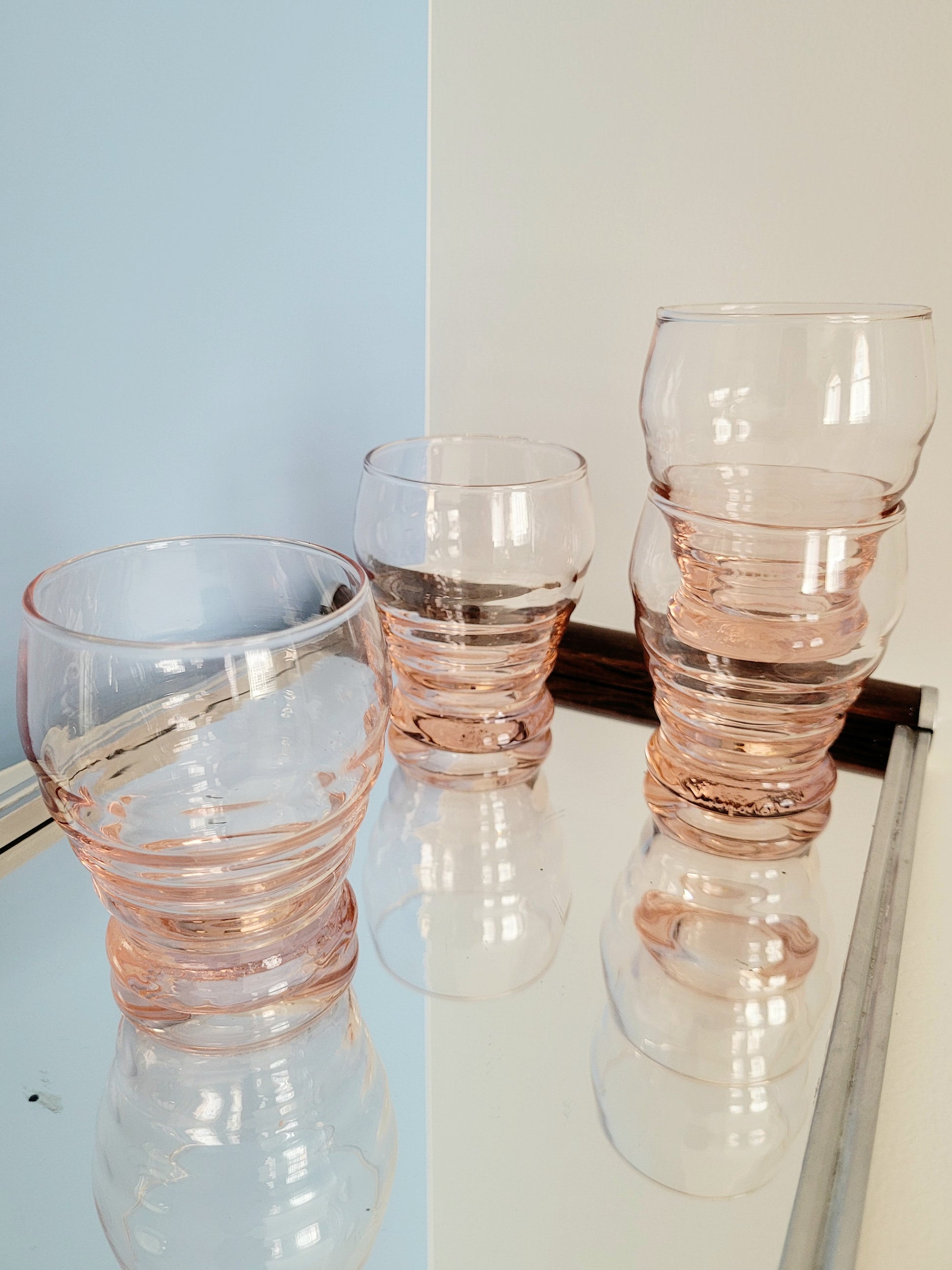 side view of coral art deco drinking glasses on a mirror tray