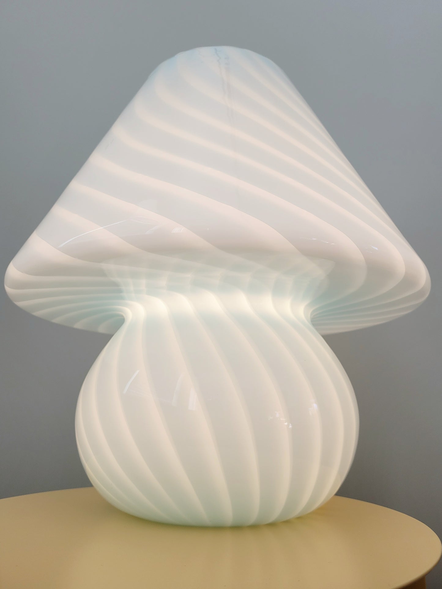 front view of a large vintage Murano blue swirl mushroom lamp illuminated
