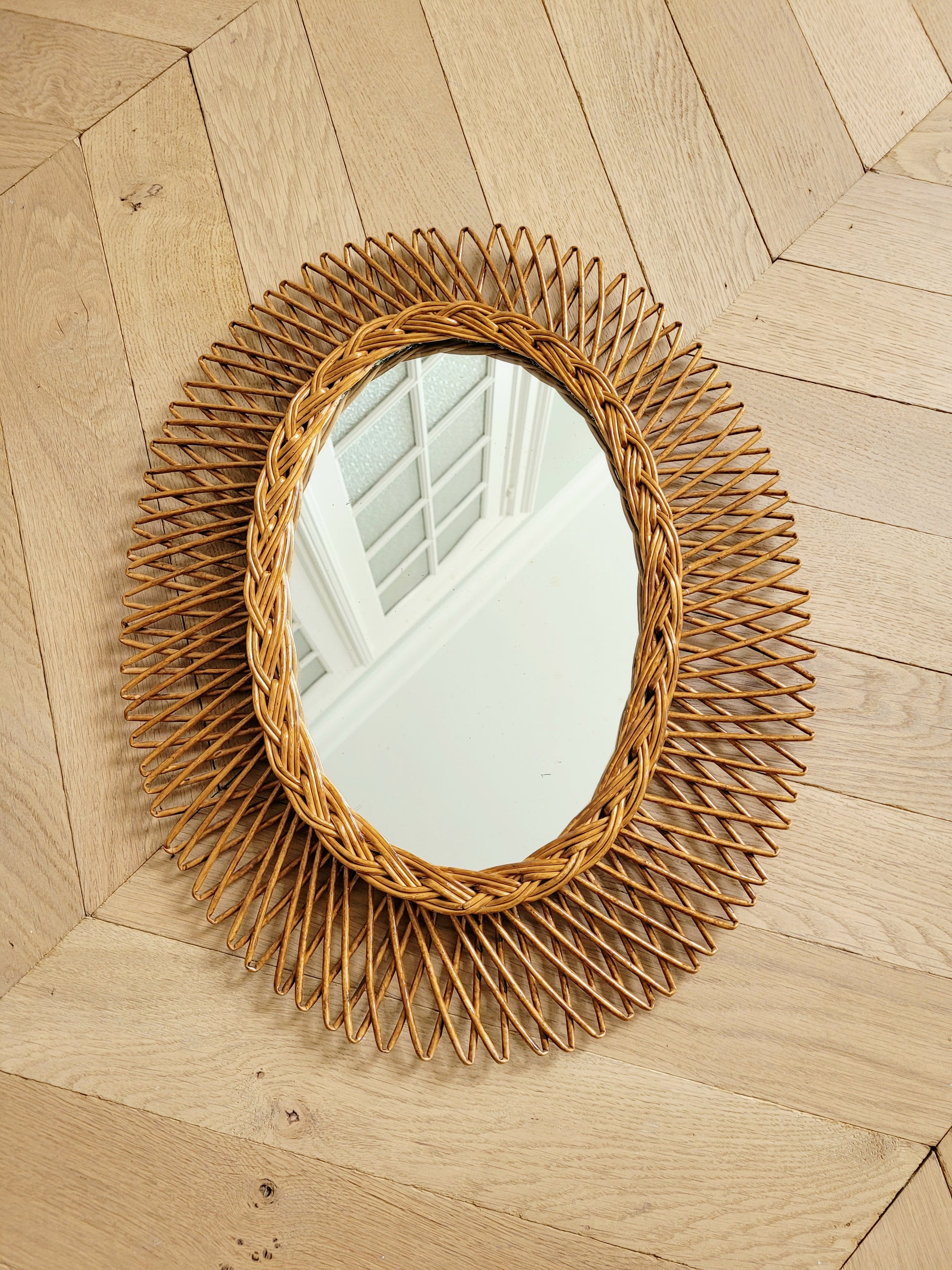 full view of an oval wall mirror in wicker texture