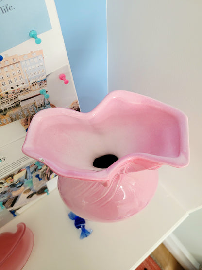 top view of a pink ceramic candy bonbon vase with a vision board next to it and a small Murano candy