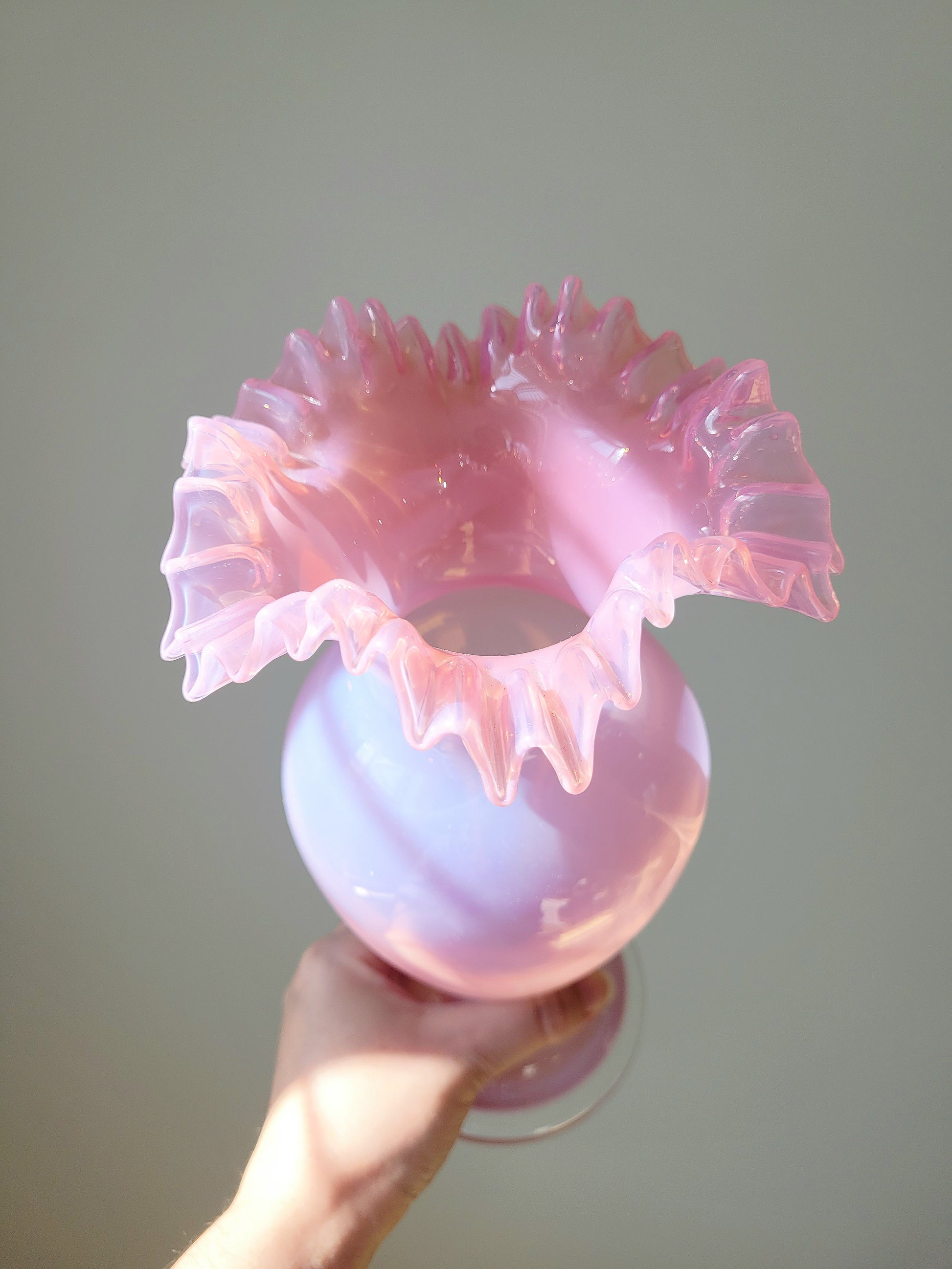 top view of a pink opaline glass vase handheld