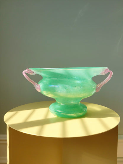 full view of a scavo Murano glass amphora vase in green and pink on a yellow side table