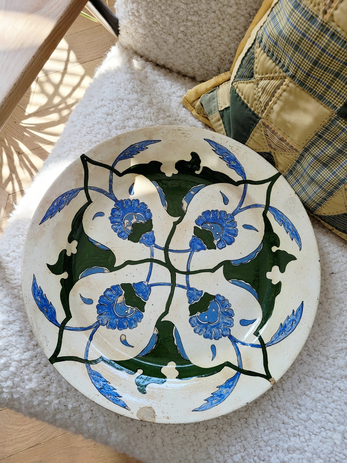 top view of a vintage Italian (wall) plate with blue and green floral motif, made by Fontebasso Treviso, Italy on a white chair